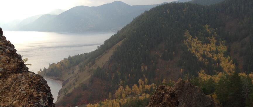 Looking down over rocky outcrops and forested hills, to the coastline far below.