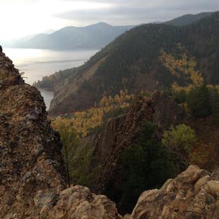 Looking down over rocky outcrops and forested hills, to the coastline far below.