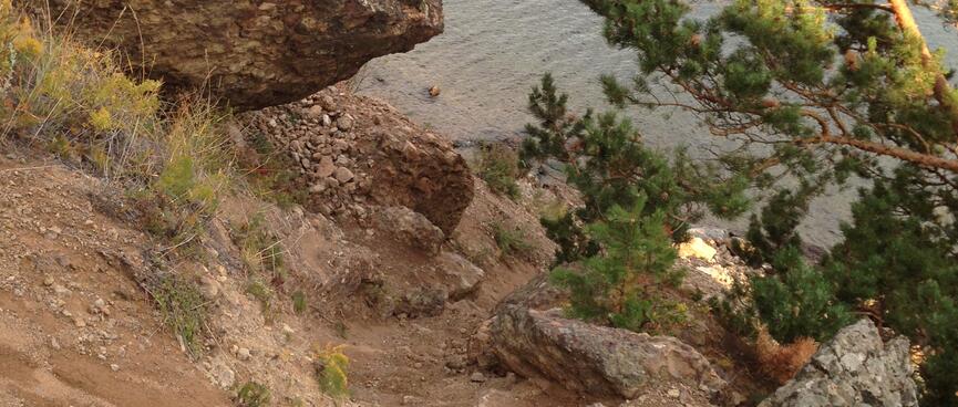 A large rock overhangs a precarious section of the track.