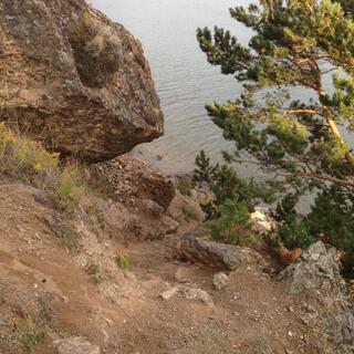 A large rock overhangs a precarious section of the track.