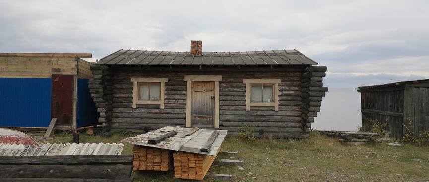 Protruding wooden beams appear to run right through a log house.