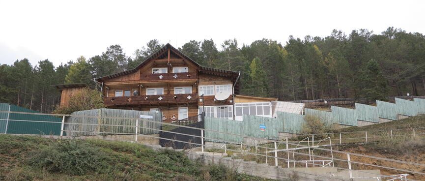 A three story wooden house with at least ten rooms.
