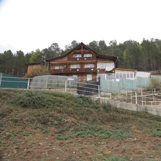A three story wooden house with at least ten rooms.