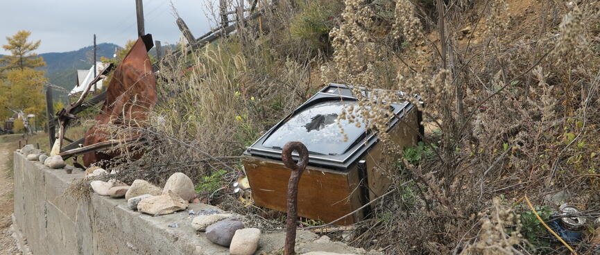 An old TV set is discarded on the side of the road.