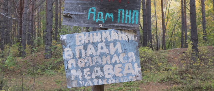 Red and white homemade signs on the trailside.