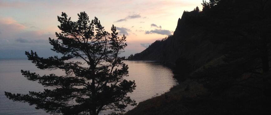 Pinky hues over a dark coastline.
