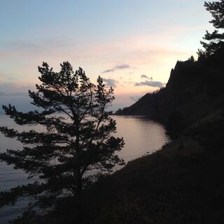 Pinky hues over a dark coastline.