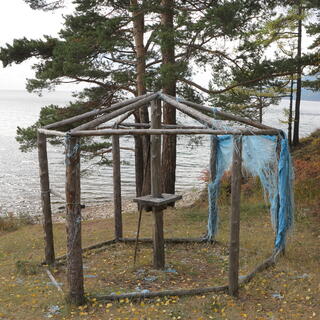 Remnants of plastic netting cling to the side of an open hexagonal structure.
