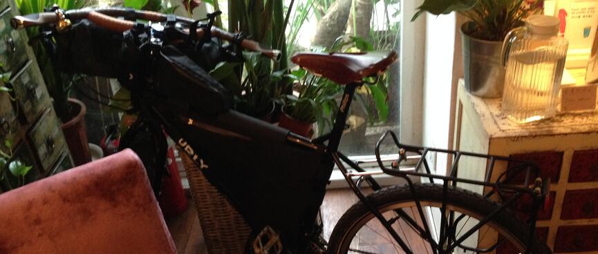 My bike is squashed between a pot plant and a lounge chair.