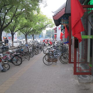 Bicycles are angle parked enmasse on the footpath.