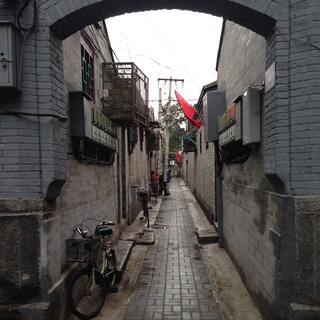 Bikes with baskets line an alleyway.