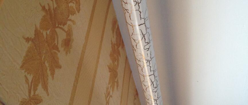 A curtain rail is painted with designer cracks.