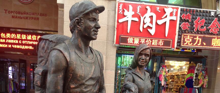 Bronze statues of a fit man, wife and child.