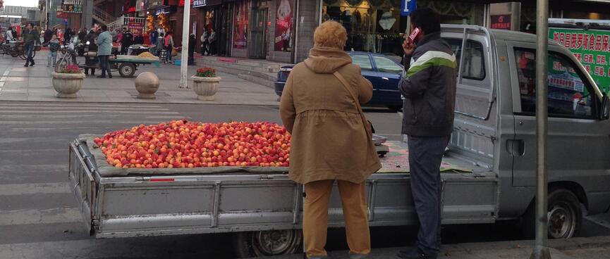 The flat deck of a small ute is covered in red apples.