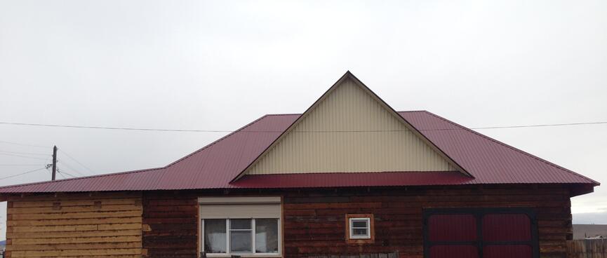 A houseʼs roof is painted crimson but its gables are cream.