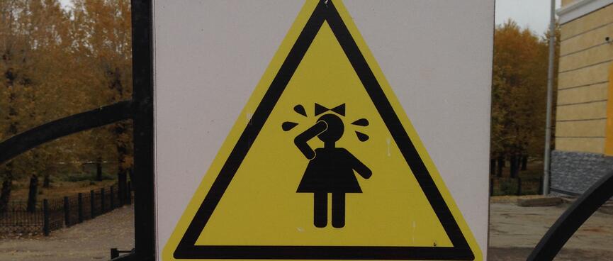 Triangle warning sign depicting a small girl crying.