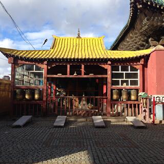 Open temple building with a yellow ridged roof.