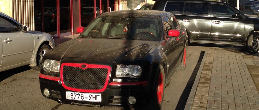 A dusty black car with contrasting red trim.