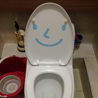 A toilet seat painted with a smiling face.