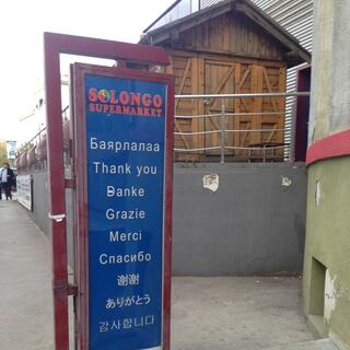 A sign for Solongo restaurant is in 9 languages.
