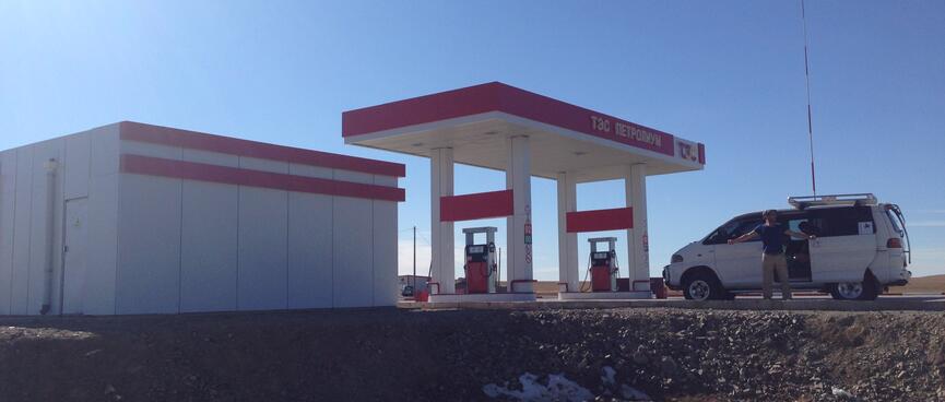 White buildings with red trim at a petrol station.