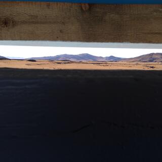 A thin slit in the toilet door provides a panoramic view of the landscape.