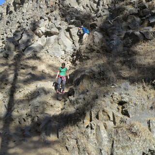 Members of the tour part pick their way down the steep rocky hillside.