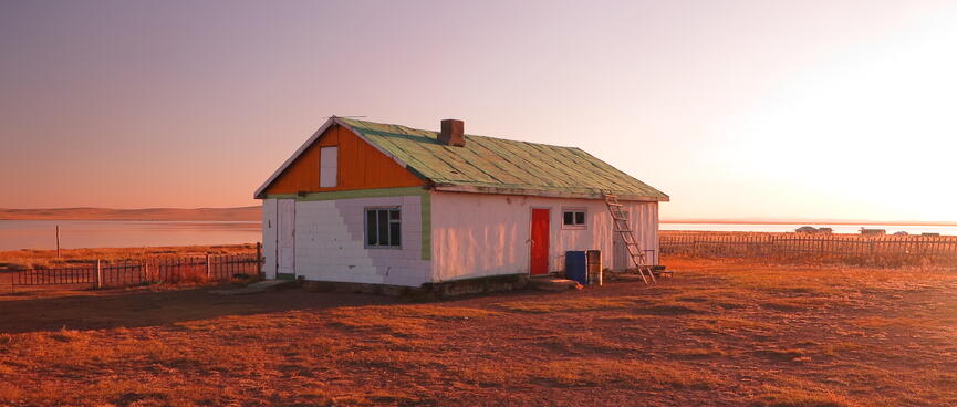A white red and green house bathed in an orange glow.