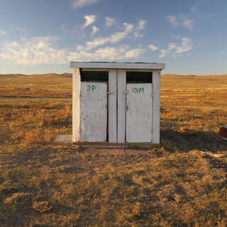 A white wooden shed with two doors.