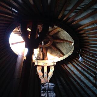 Looking up at a partially open ventilation hole in the center of the ger roof.
