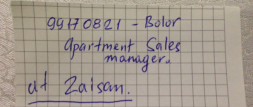The name and number of a real estate agent is scrawled on graph paper.