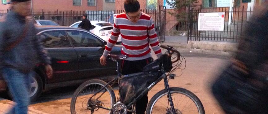 A man in a red and white striped jumper looks down at my touring bike.