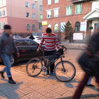A man in a red and white striped jumper looks down at my touring bike.