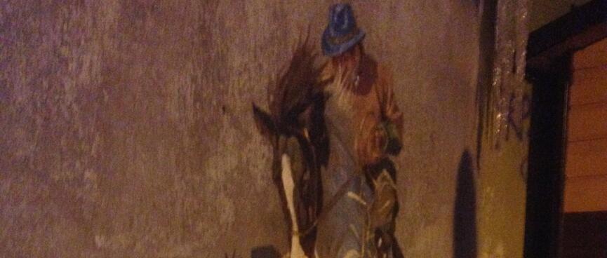 A mural of a man on a rearing horse.