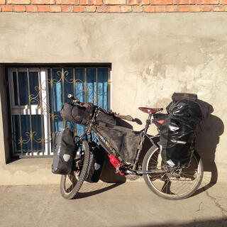 The rear rack of my touring bicycle is piled high with gear.