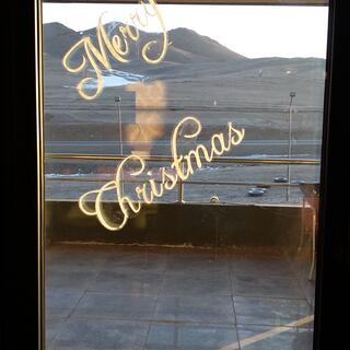 Merry Christmas is diagonally stencilled on a window.
