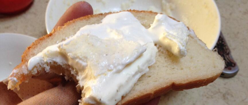 Soft yellow cheese with a white outer, spread onto a slice of bread.