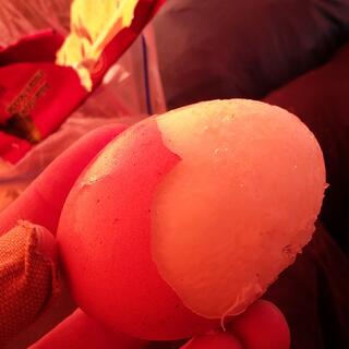 The frozen white of a partially shelled boiled egg.