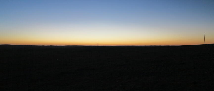 Blue sky and an orange strip above the black horizon.