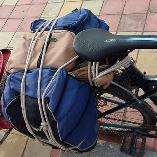 Blue and brown packs neatly roped onto the rear rack of a bicycle.