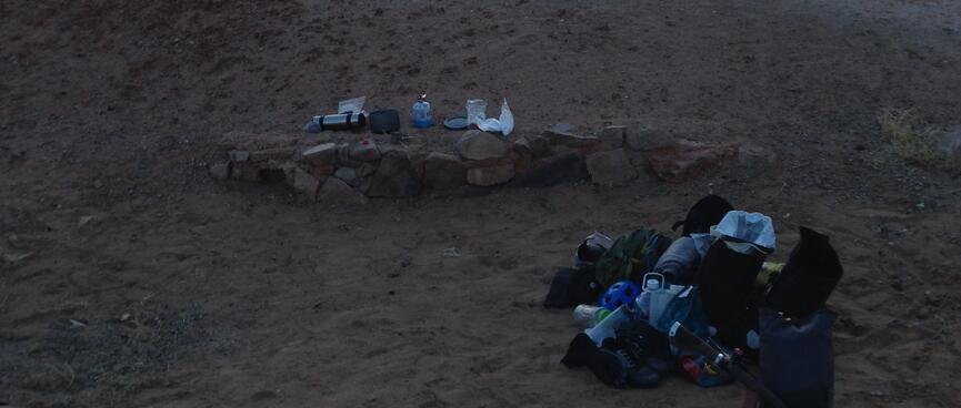 Cooking gear is laid out in a sandy shallow.