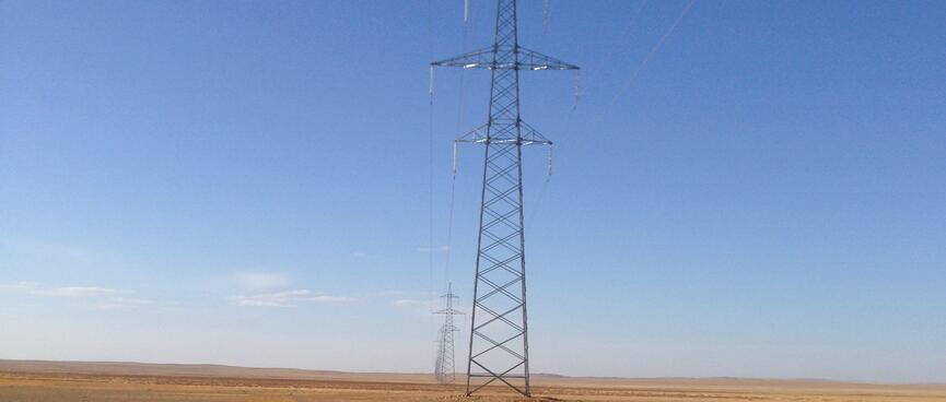Ahead, a line of tall power pylons extends as far as the eye can see.