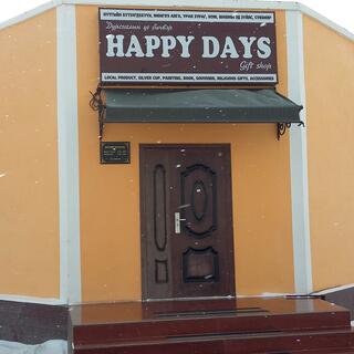 The Happy Days gift shop is an angular orange building with a large sign above the brown door.