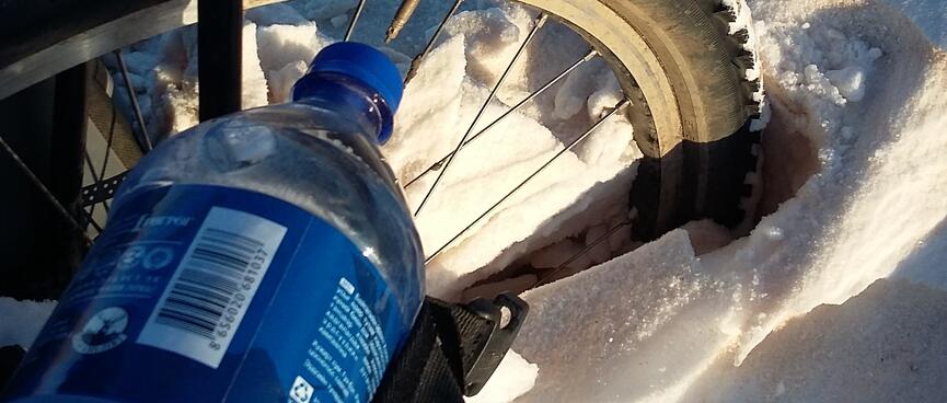 My bikeʼs front wheel is half submerged in fresh powder.