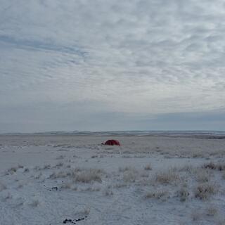 My orange tent in a snowy field.
