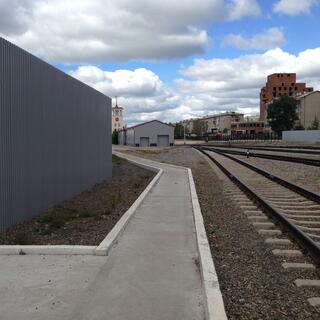 A clean and angular concrete path runs parallel to railway tracks, at Zabaikalsk station.