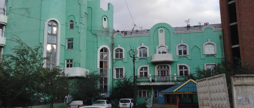 A three story apartment block with interesting arched windows, in Zabaikalsk.