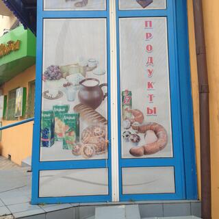 A poster advertises bread, cheese, sausage, milk and fruit juice, in Chita.
