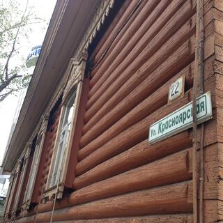 Wooden half-rounds cover the wall of an ancient log cabin, in Chita.