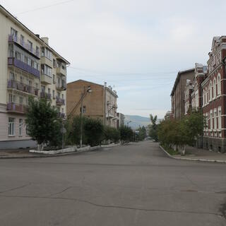 Three story apartment blocks line a deserted street, in Chita.